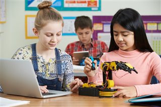 Two girls working together on a robotics project.
